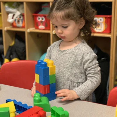 rock-spring-childrens-center8 Toddler building with large plastic blocks in the classroom